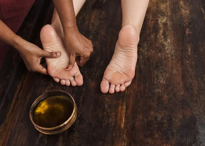 Ayurvedic foot massage treatment with herbal oil at a wellness spa offering ayurvedic massage in Coimbatore.
